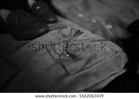 Composition from clothes. Shirts and a jacket with loafers on a dark background. Clothing. Black and white photo.