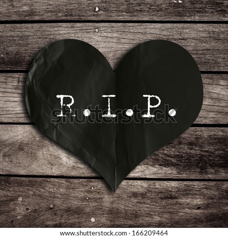 R.I.P. word on black heart shape with wooden wall,broken heart concept