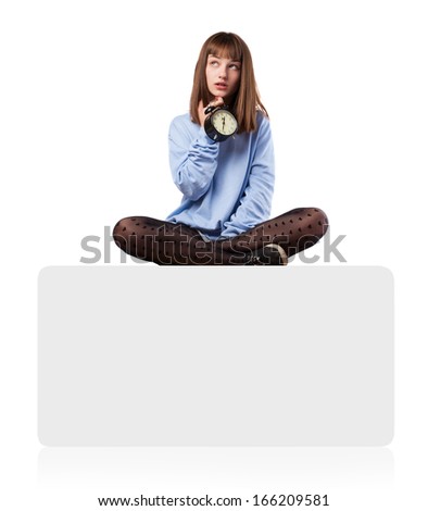 worried young woman with an alarm clock sitting on a white box