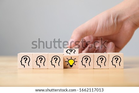 Concept creative idea and innovation. Hand flip over wooden cube block with head human symbol and light bulb icon Royalty-Free Stock Photo #1662117013