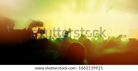 social media concept crowd people hand hold smartphone capture exitied moment in colorful lighting concert event with abstract blur bokeh background