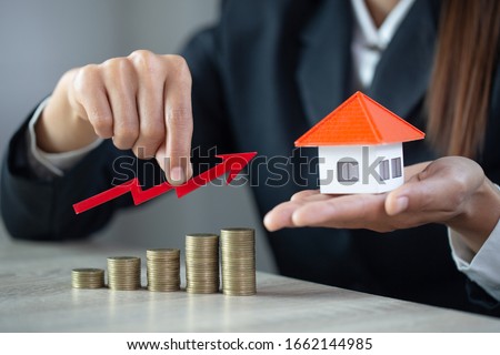 Businessman Holding  Graph Over The Increasing House Miniature, Real estate investment,investment mortgage finance and home loan business, growth and money. Royalty-Free Stock Photo #1662144985