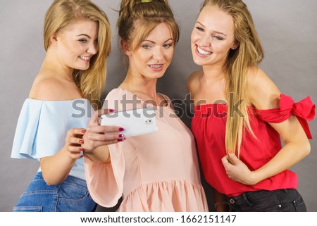 Fashionable women taking selfie self picture using smartphone having fun enjoying friends time.