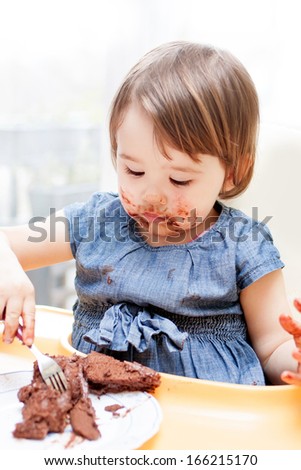 Little girl enjoying her birthday cake. 