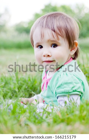 Cute little girl on the meadow in spring day.