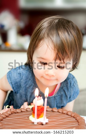 Little girl enjoying her birthday cake. 