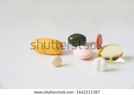 Pills in a row, various forms, white background. Multi-colored pills close-up and copy space.