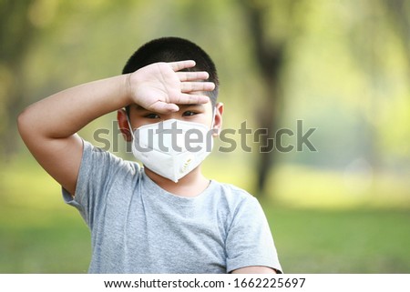 A young Asian boy , 7 Years Old , wear mask to protect against dust PM 2.5 and germs Royalty-Free Stock Photo #1662225697