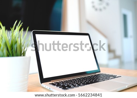 Computer Laptop with blank screen on table of liveing room blur background with bokeh, desk blank work office mockup monitor