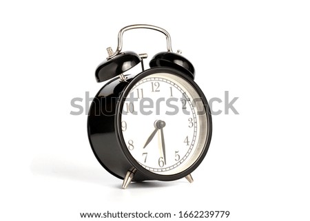 Closeup retro black alarm clock isolated on white background with clipping path, perspective view