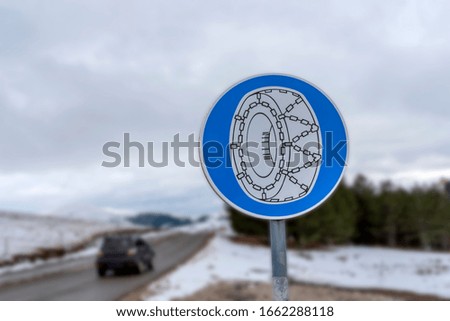 Blue road snow car chain on rod with blurred background