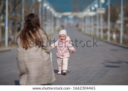 A little baby girl is crying scared in the street. Copy space. Concept: children's cry, family, problems of motherhood.