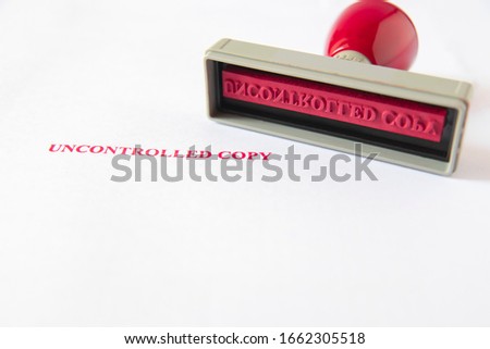 Old rubber stamp, used office equipment, then put on white paper  and a red UNCONTROLLED COPY message, for control and uncontrol document , or knowhow in company or work and include all in world.