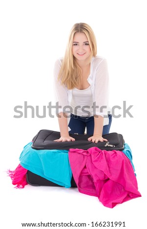 young attractive woman packing suitcase isolated on white background