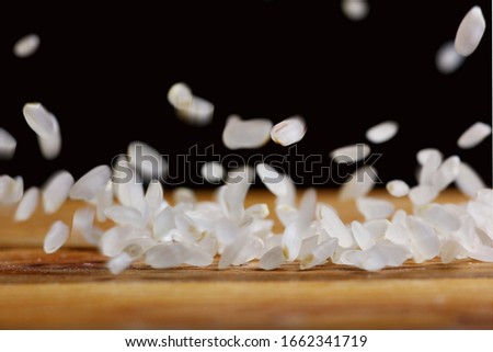 rice grains falling on a wooden table