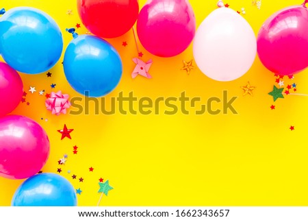 Party concept. Colorful balloons and confetti on yellow background top-down frame copy space