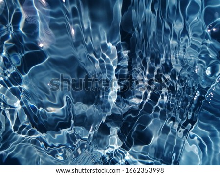 The​ abstract​ of​ surface​ blue​ water​ in​ the​ deep​ sea​ for​ background. Blue​ water​ texture​ for​ background. Blue​ water​ splash​ed​ for​ background​