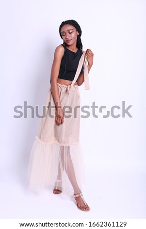 Female beauty concept. Portrait of fashionable young african model girl in trendy clothes posing over white studio background. Perfect hair & skin. Studio shot in summer outfit
