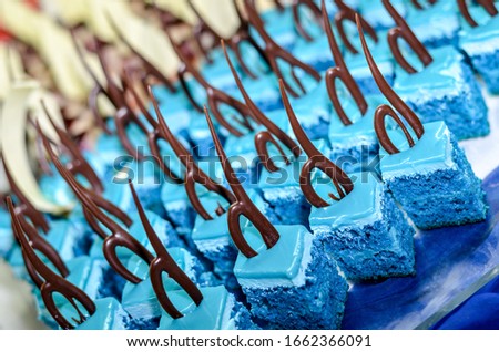 Tray full of cupcakes and slices of cake inside a buffet