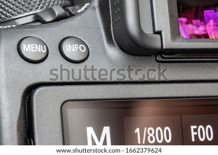 The back of digital camera with Menu and Info buttons above display, close up.