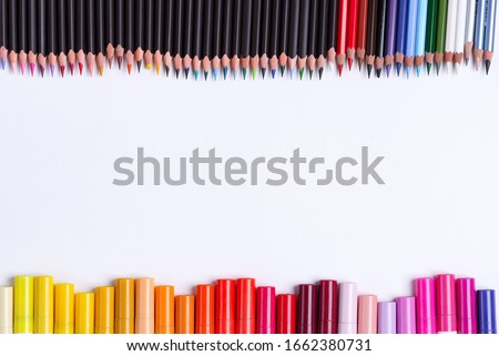 Painting multicolored border from colorful markers and pencils for art creativity on a white background. Flat lay
