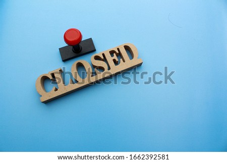 wooden "closed" sign with rubber stamp. business deal concept photo. blue background.
