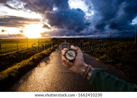 
landscape photo and a compass in a hand. travel concept.