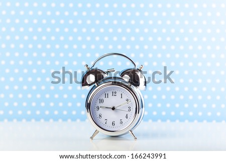 Retro alarm clock on a table. Photo in retro color image style
