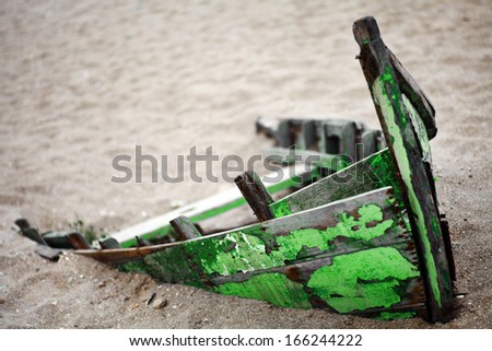 Color picture of an abandoned boat stuck in sand