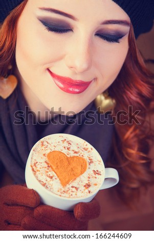 Redhead girl with red coffee cup.