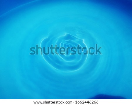 The​ pattern of​ surface​ blue​ water in​ the​ swimming​ pool reflected​ with​ sunlight​ for​ blue water. Abstract of surface​ blue water​ for​ background​