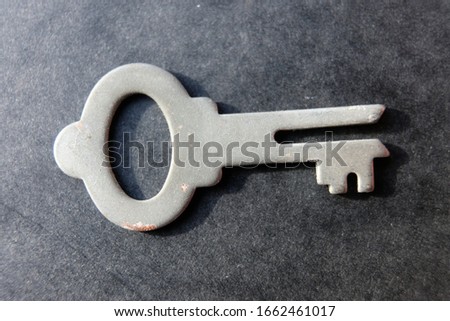 a silver key on a black background