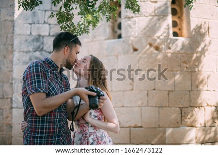 Lovers take pictures of attractions near the stone wall of the temple. A couple of newlyweds admire the ancient church. Honeymoon on Travel