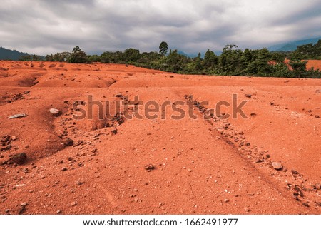 Texture of rough red land in rural Indonesia, pictured on a warm day on the hills in Padang, West Sumatra.