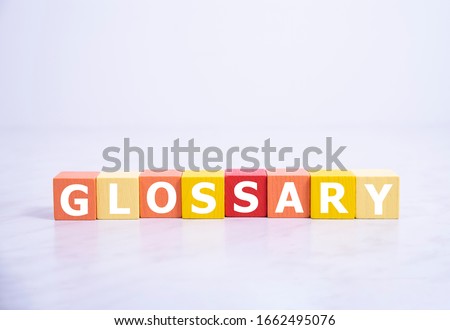 Glossary - word from wooden blocks with letters, alphabetical list with words meanings dictionary glossary concept, top view on white background