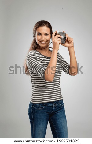 Portrait of a beautiful woman shooting with a vintage camera