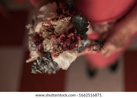 Elderly woman holding a wedding bouquet of roses. Golden Weddings. Colorful Bouquet.