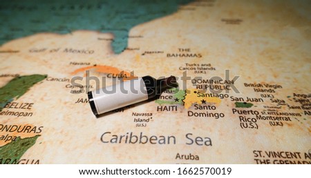 A bottle of red wine on a map of Cuba and Haiti.