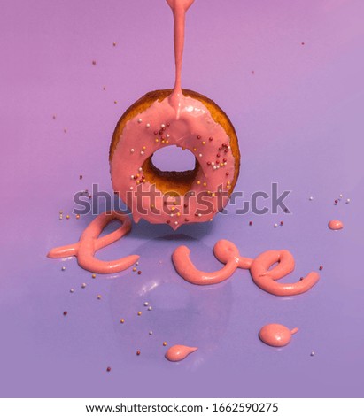 donut with pink icing and 
love lettering