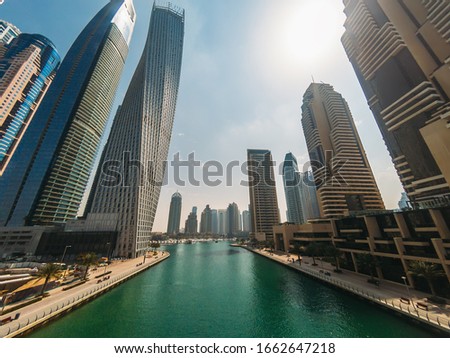 Dubai Marina canal in summer day with high buildings, UAE emirates.