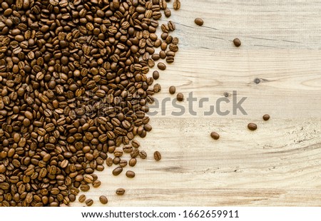 Fragrant coffee beans scattered on a wooden background. Top view.