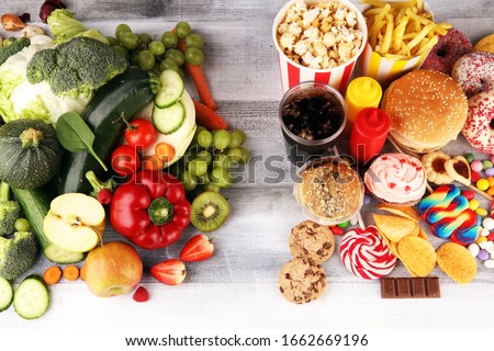 healthy or unhealthy food. Concept photo of healthy and unhealthy food. Fruits and vegetables vs donuts,sweets and burgers on table Royalty-Free Stock Photo #1662669196