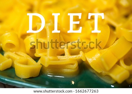 Word DIET. macaroni alphabet letters ongreen plate. Durum wheat pasta for children s table. Pasta diet concept