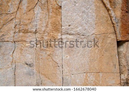 Square Cracked Volcanic Tuff Rock Natural Background Pattern with a design of straight lines forming squares that look like a quarry