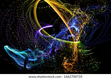 Purple and blue with green and orange overlay composite of a pixel whip shot with long exposure to create an abstract trails effect