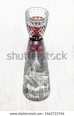 Optical 3d effect of a red wine glass with rhomboid ornamments creating vase shape.