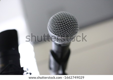 A soft focus closeup shot of a dynamic microphone on a stand