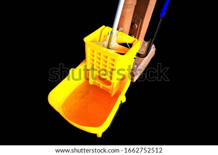 Yellow bucket and set of cleaning equipment on the wall in  the rail way station blur background