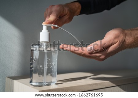 Hand sanitizer alcohol gel rub clean hands hygiene prevention of coronavirus virus outbreak. Man using bottle of antibacterial sanitiser soap. Royalty-Free Stock Photo #1662761695