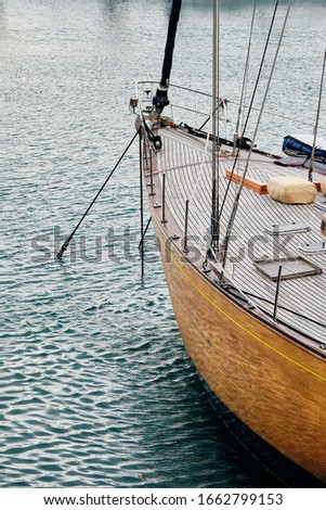 A vertical picture of a sailing boat on the sea under the sunlight